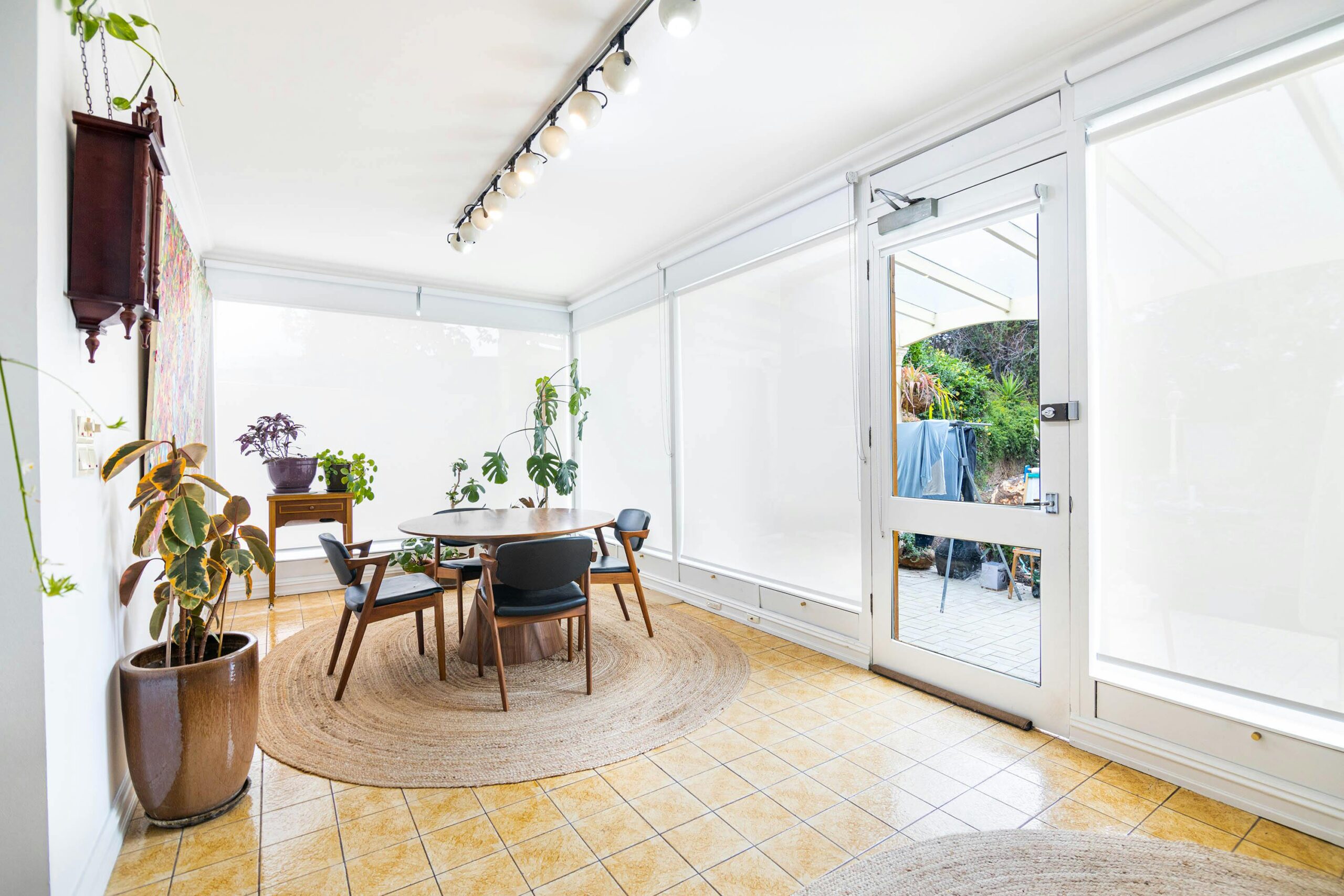 Spacious and well-lit indoor dining area in Melbourne with minimalist decor and lush indoor plants.
